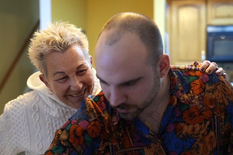 Deb Robertson smiles as she converses with her son Jake before a BBQ with family and friends at her Lombard, Ill., home Saturday, March 23, 2024. (AP Photo/Charles Rex Arbogast)
